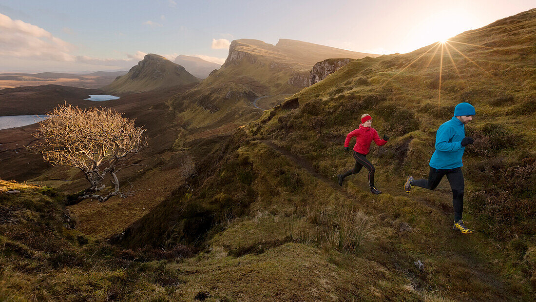 Young couple running on a trail, Quiraing, Trotternish peninsula, Isle of Skye, Scotland, United Kingdom