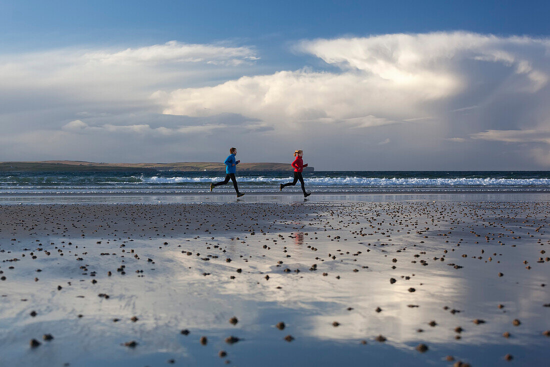 Young couple running at beach, Dunnet Bay, Caithness, Scotland, United Kingdom