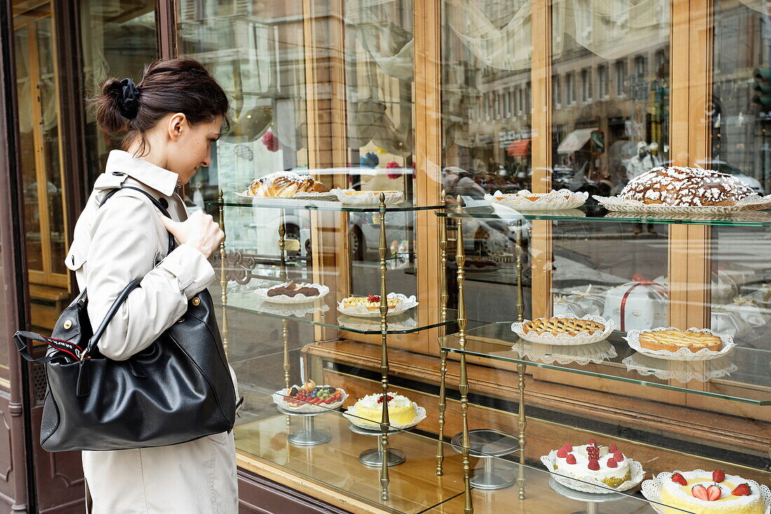 Woman looking at a shop window of a patisserie, Corso Magenta, Milan, Lombardy, Italy