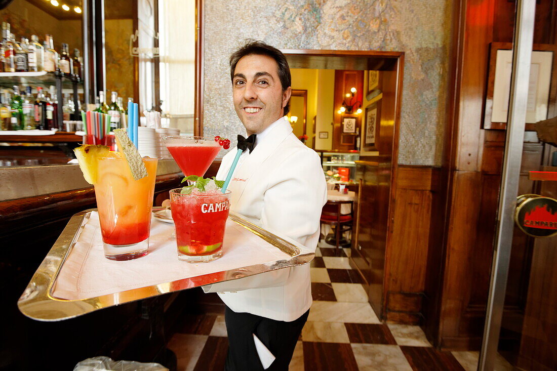 Waiter serving several drinks in a bar, Galleria Vittorio Emanuele II, Milan, Lombardy, Italy