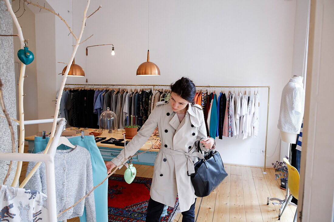 Woman shopping in a fashion boutique, Navigli, Milan, Lombardy, Italy