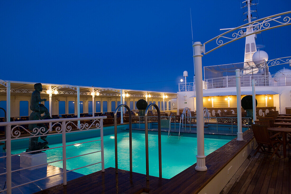 Swimming pool and cruise ship MS Deutschland (Reederei Peter Deilmann) at dusk, Atlantic Ocean, near Greenland