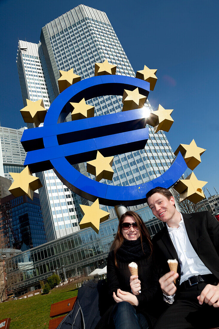 Couple eating ice cream by the Euro monument and the European Central Bank, Frankfurt, Germany