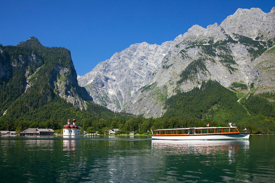 Excursion boat in front of baroque style pilgrimage church St Bartholomae, Watzmann east wall in the background, Koenigssee, Berchtesgaden region, Berchtesgaden National Park, Upper Bavaria, Germany