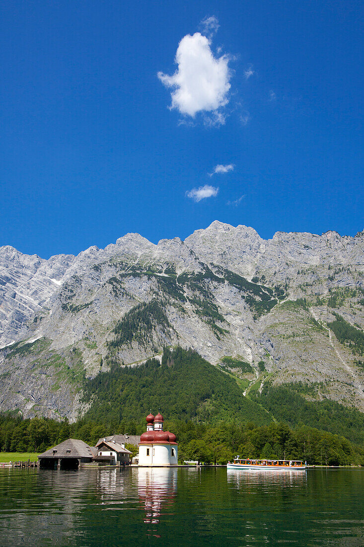 Excursion boat in front of baroque style pilgrimage church St Bartholomae, Watzmann east wall in the background, Koenigssee, Berchtesgaden region, Berchtesgaden National Park, Upper Bavaria, Germany