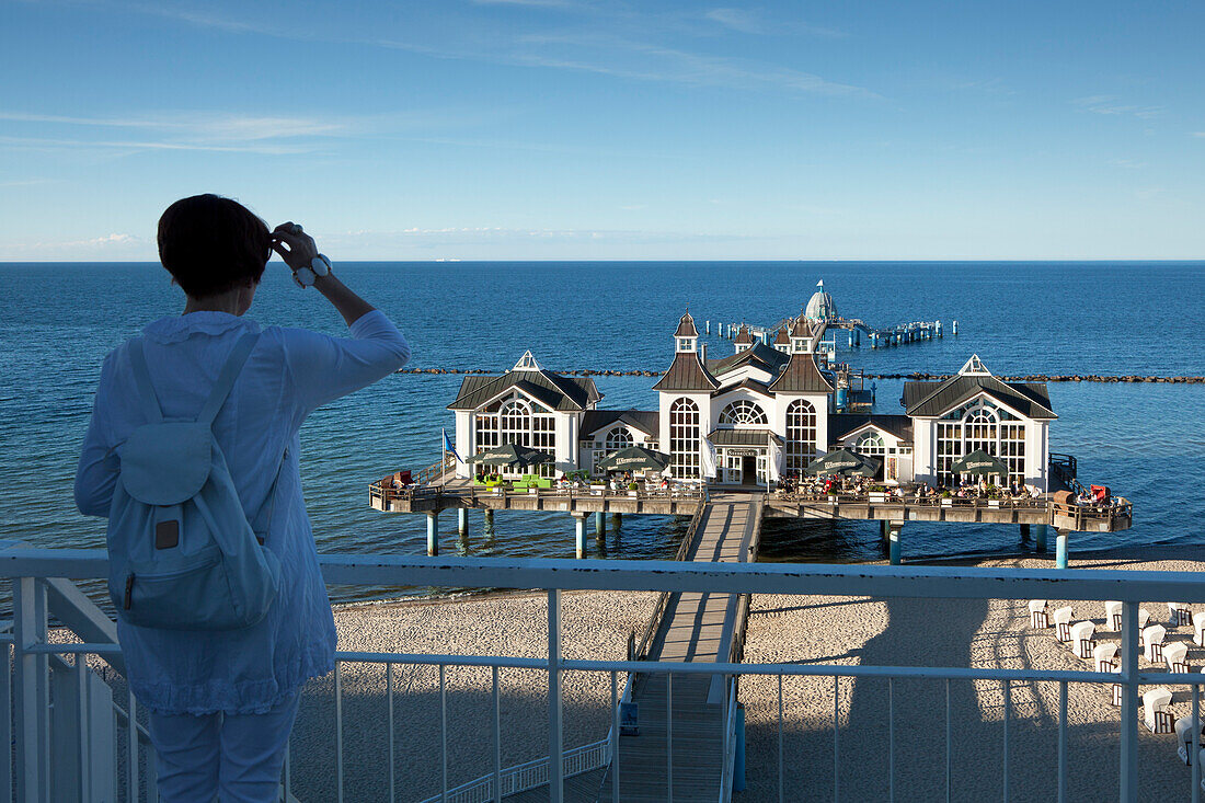 Woman looking towards Sellin pier, Sellin, Ruegen island, Baltic Sea, Mecklenburg Western-Pomerania, Germany