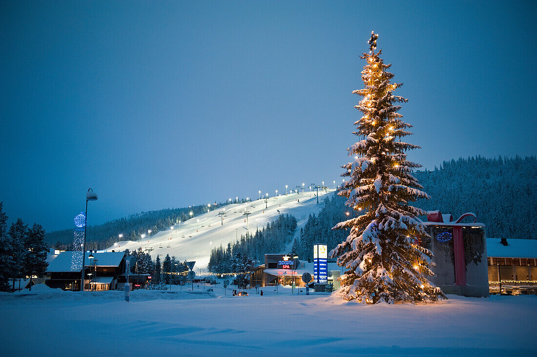 A Large Decorated Christmas Tree With Lights In Front Of The Floodlit And Ski Slopes, Levi, Lapland, Finland