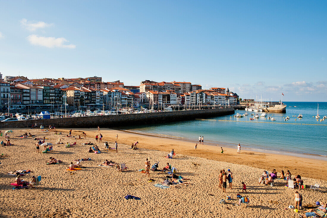 Incidental People Sunbathing On The Beach At Lekeitio, Basque Country, Spain