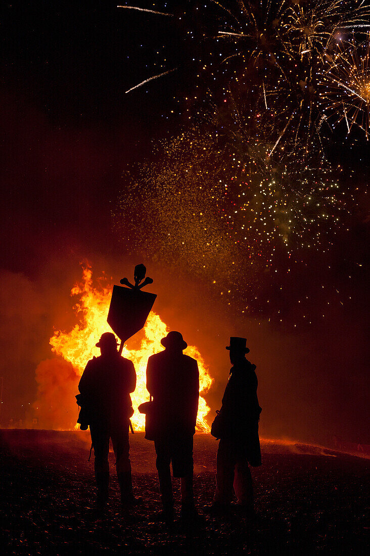 Silhouette Of Men In Front Of Large Bonfire On Beach, Hastings Bonfire Night, East Sussex, Uk