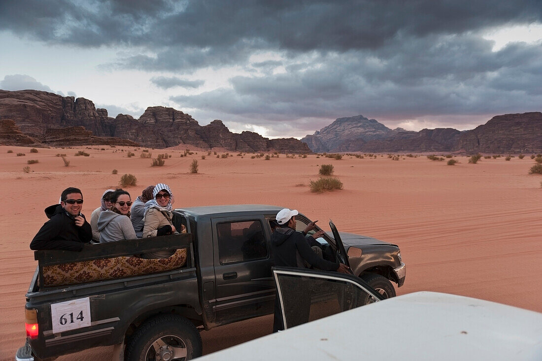 Tourists Sitting In The Back Of A 4X4 Vehicle Before Being Transported To A Captain's Eco Desert Camp, Wadi Rum, Jordan, Middle East