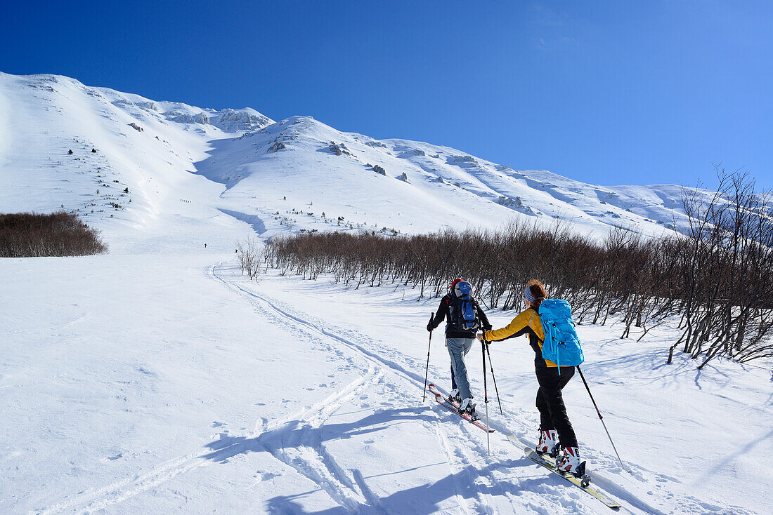 Zwei Skitourengeherinnen steigen zum Monte Amaro auf, Rava Giumenta Bianca, Majella, Abruzzen, Italien