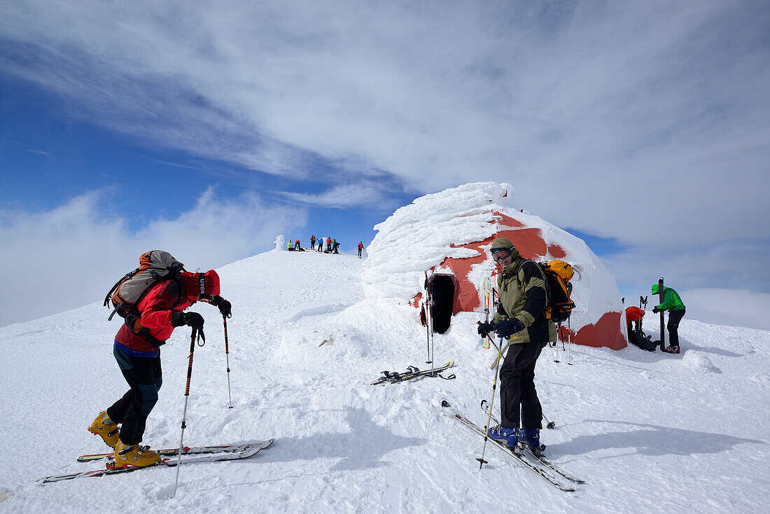 Gruppe von Tourengehern steht am Gipfel des Monte Amaro vor verschneiter Biwakschachtel, Monte Amaro, Majella, Abruzzen, Apenninen, l 'Aquila, Italien