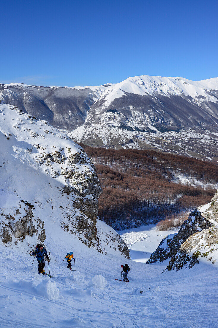 Three backcountry skiers ascending to Monte Pesco Falcone, Rava del Ferro, Maiella, Abruzzo, Italy