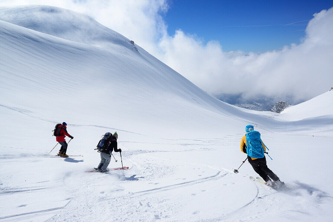 Drei Skitourengeher fahren vom Monte Pesco Falcone ab, Rava del Ferro, Majella, Abruzzen, Italien