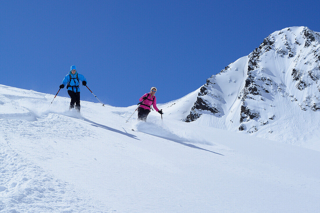 Two female backcountry skiers downhill skiing, Gleirscher Rosskogel, Pforzheim Hut, Sellrain, Stubai Alps, Tyrol, Austria