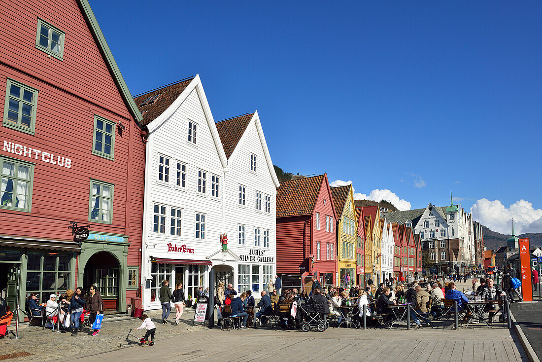 Personen sitzen im Café, Hansehäuser im Hintergrund, Bryggen, UNESCO Weltkulturerbe Bryggen, Bergen, Hordaland, Norwegen