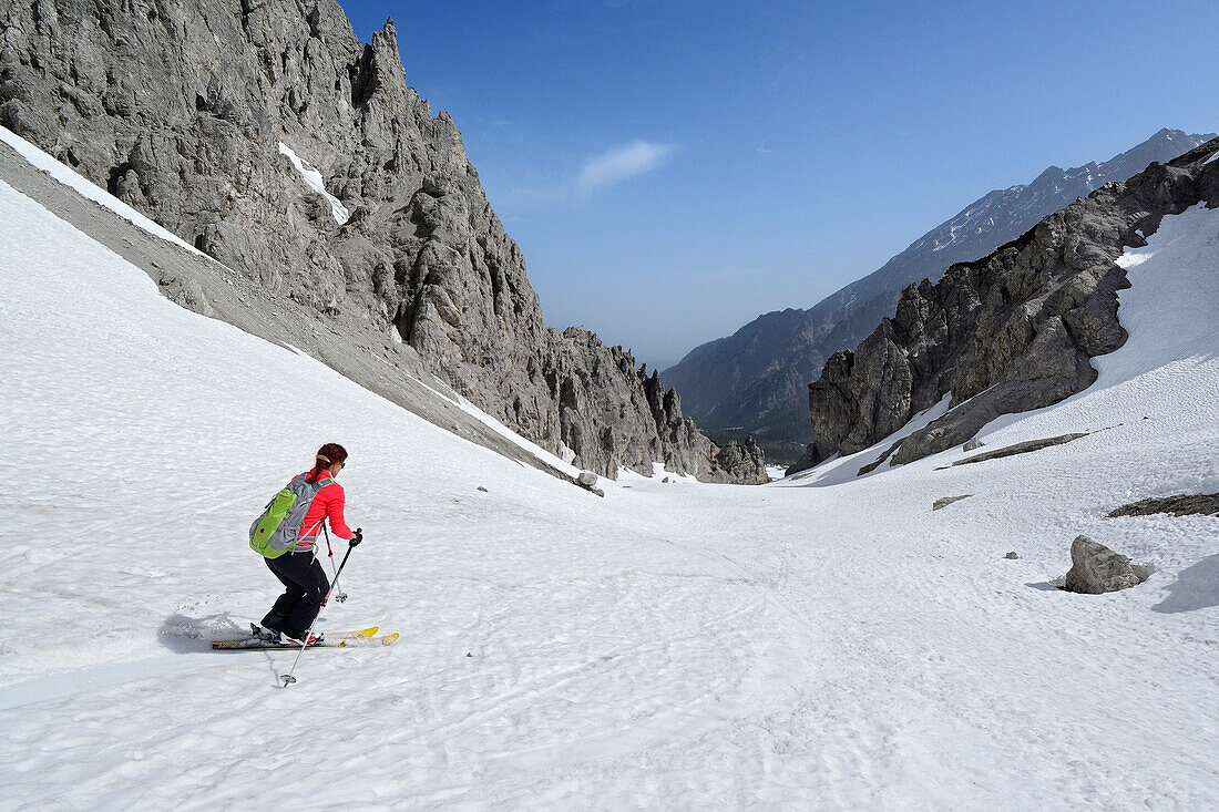 Female backcountry skier downhill skiing through Loferer Seilergraben, Berchtesgaden Alps, Berchtesgaden National Park, Upper Bavaria, Bavaria, Germany