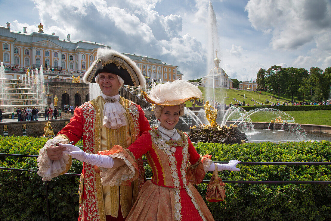 Couple in traditional period costumes at the Grand Cascade fountains at Peterhof Palace (Petrodvorets), St. Petersburg, Russia, Europe