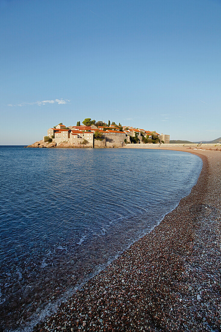Blick am Strand entlang auf Sveti Stefan in der Adria, Budva, Montenegro