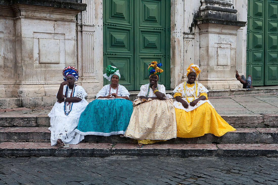Vier ältere Damen in traditioneller Tracht sitzen auf Stufen in der Pelourinho Altstadt, Salvador, Bahia, Brasilien, Südamerika