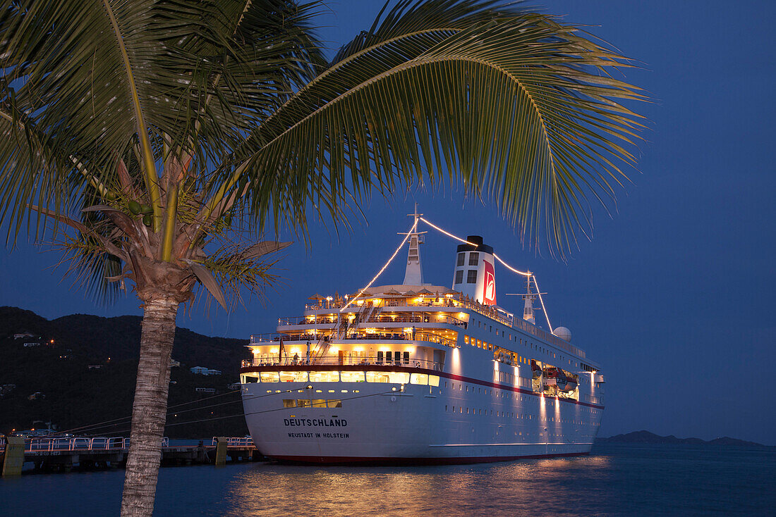 Eine Palme und das Kreuzfahrtschiff MS Deutschland (Reederei Peter Deilmann) an der Pier in der Abenddämmerung, Tortola, Tortola, Britische Jungferninseln, Karibik
