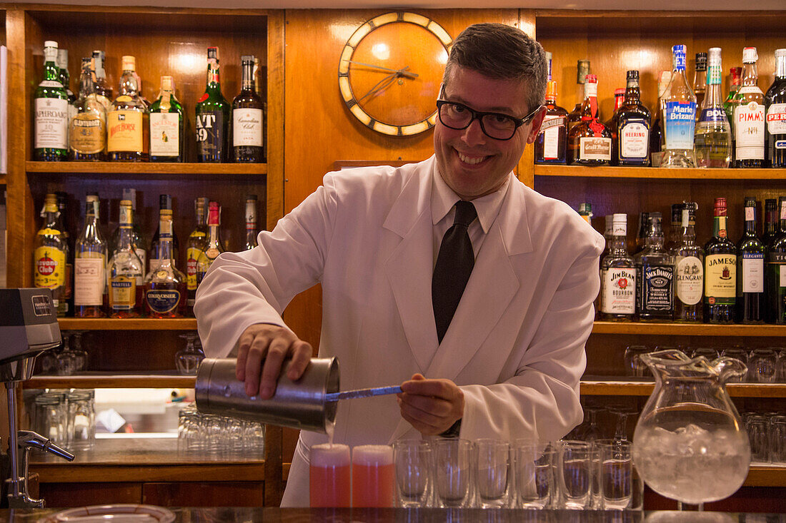 Freundlicher Barkeeper in Harry's Bar mixt köstliche Bellini Cocktails, Venedig, Venetien, Italien, Europa