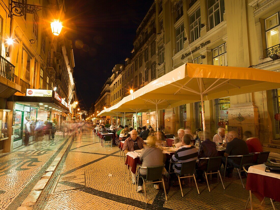 Portugal Lisbon. People in outdoor restaurant in Rua Augusta at evening.