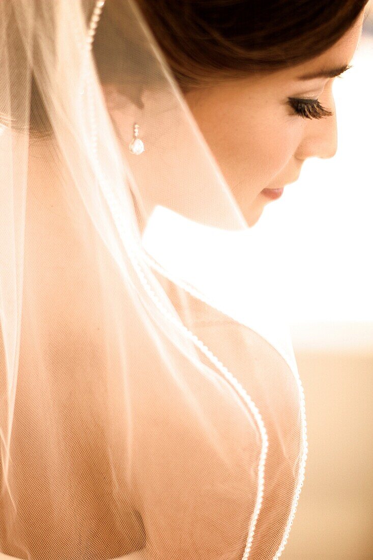 gorgeous bride preparing and anticipating her wedding after hair, makeup, veil, wedding dress are perfect