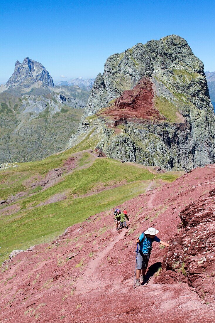 Hikers walking to summit of Anayet, an old volcano in Tena valley, and view of Midi d´Ossau Peak France  Formigal  Sallent de Gállego  Pyrenees  Huesca province  Aragón  Spain