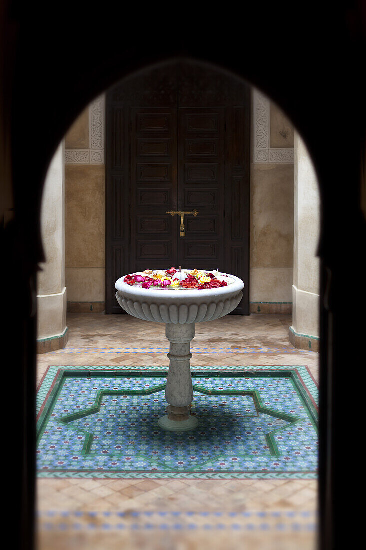 Flowers in water fountain in courtyard, Dar Les Cigognes, Marrakech, Morocco
