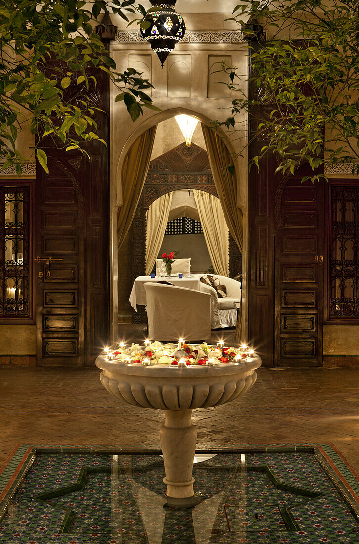 Flowers in water fountain in courtyard, Dar Les Cigognes, Marrakech, Morocco