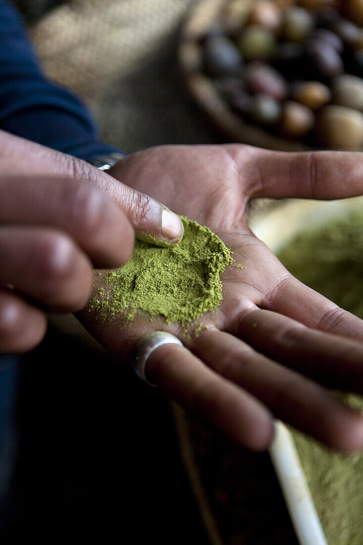 Man showing a powder in the spice market, Marrakech, Morocco