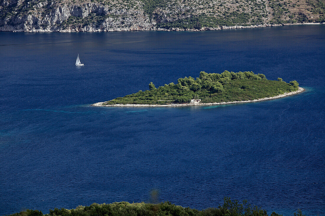 Boot in der Nähe einer kleinen Insel mitten im Meer, Hvar, Dalmatien, Kroatien
