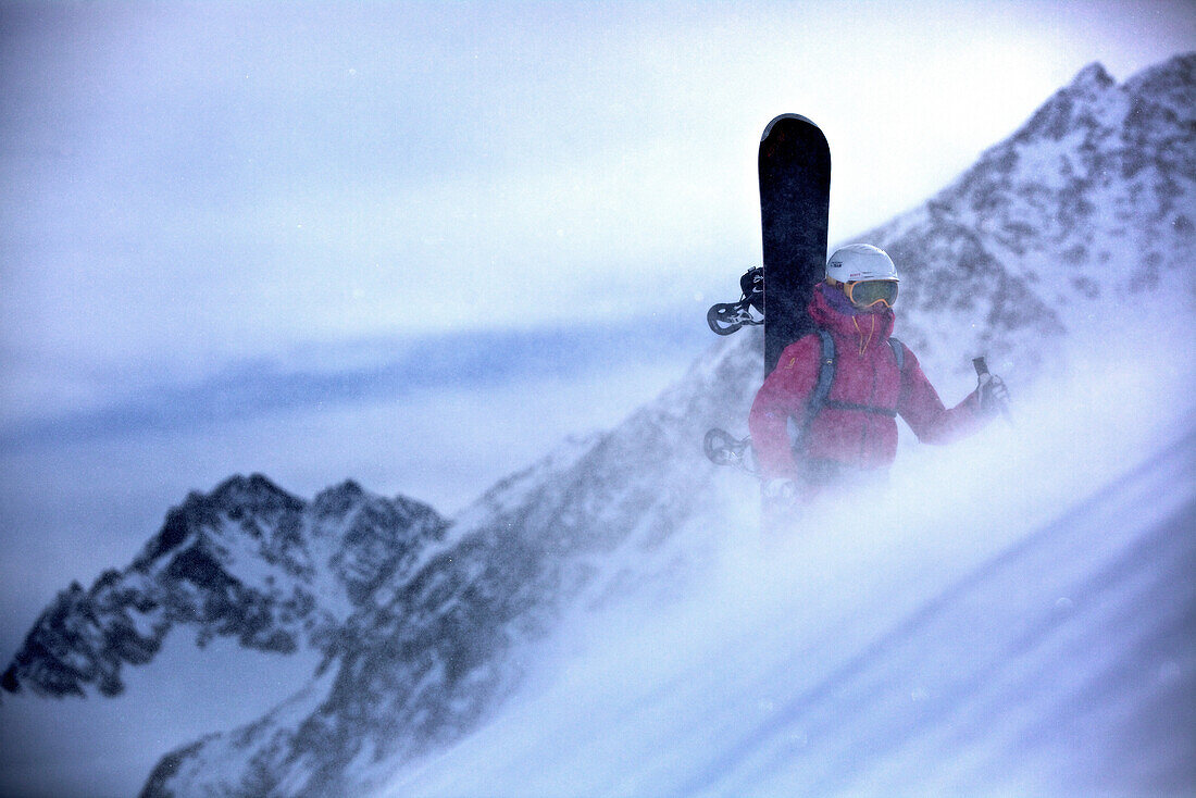 Snowboarderin steigt durch den Schnee in den Bergen, Pitztal, Tirol, Österreich