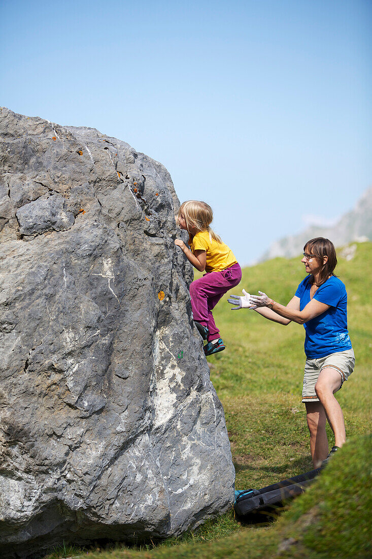 A girl and a woman bouldering, climbing, Engstligenalp, Bernese Oberland, Switzerland