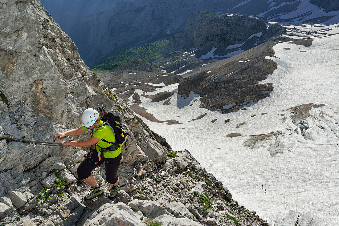 Woman ascending on fixed rope route to Zugspitze, glacier Hoellentalferner in background, Wetterstein mountain range, Upper Bavaria, Bavaria, Germany