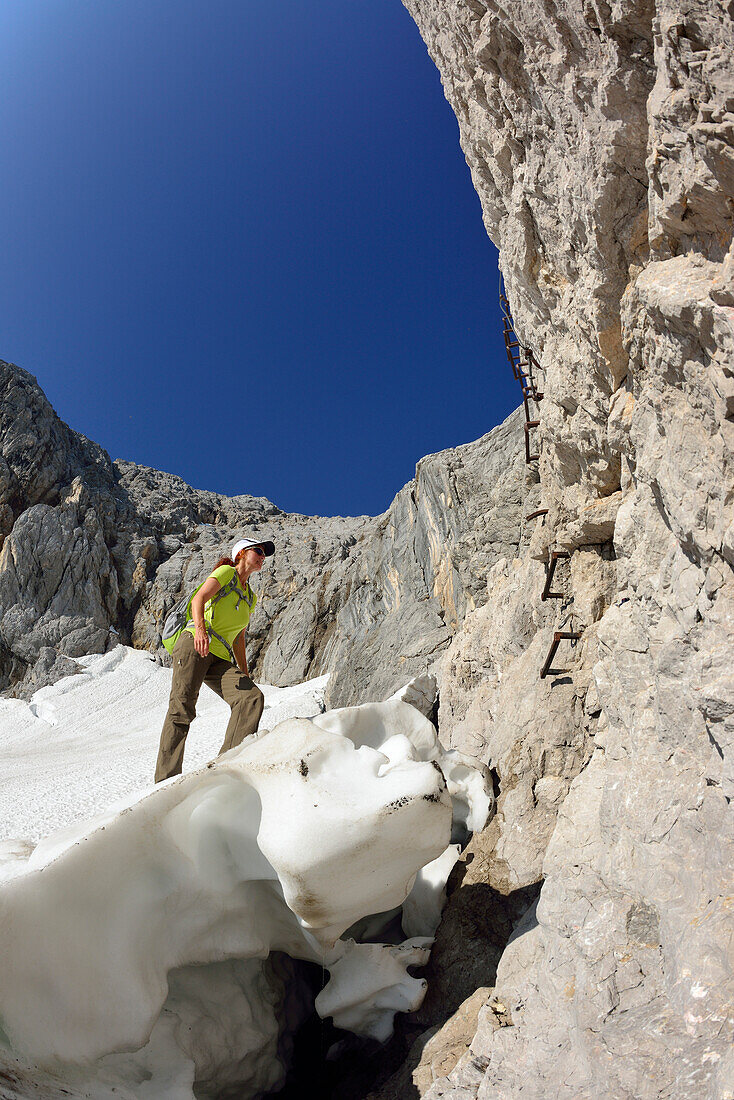 Woman ascending from glacier Hoellentalferner to fixed rope route to Zugspitze, Wetterstein mountain range, Upper Bavaria, Bavaria, Germany