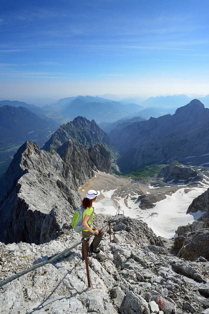 Woman ascending on fixed rope route to Zugspitze, glacier Hoellentalferner in background, Wetterstein mountain range, Upper Bavaria, Bavaria, Germany