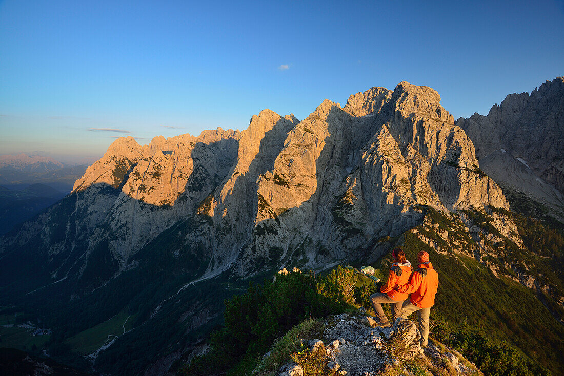 Two persons enjoying view from Stripsenkopf to mountain scenery, Zahmer Kaiser, Kaiser mountain range, Tyrol, Austria