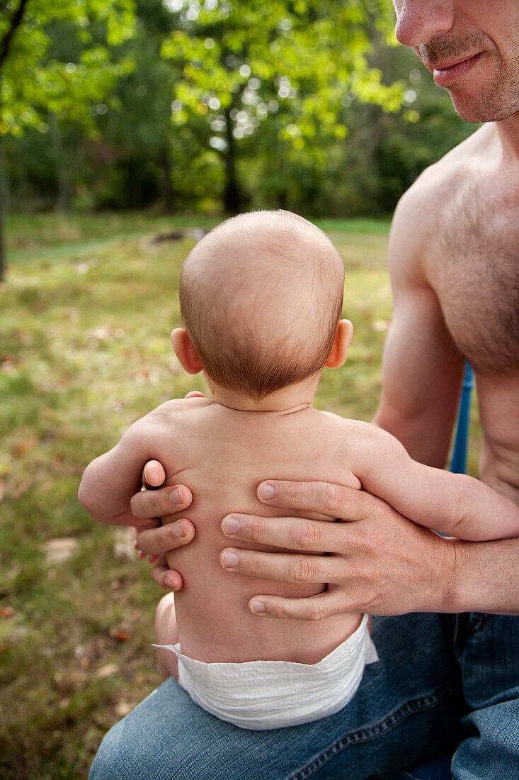 Father Holding Baby in Diaper on Lap