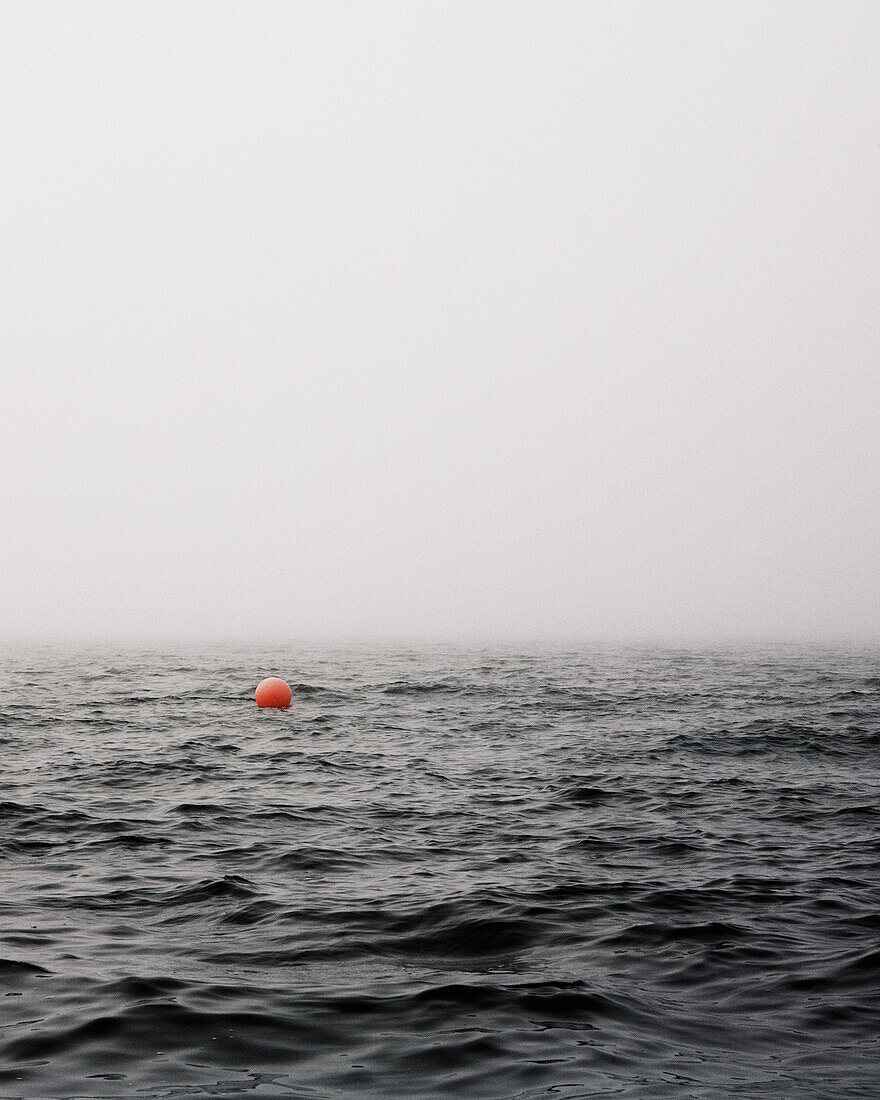 Red Mooring Buoy in Ocean on Foggy Day