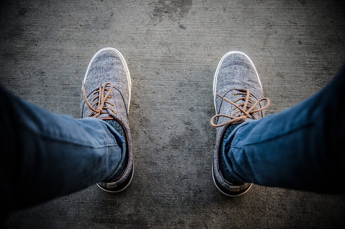 POV of Man's Casual Shoes on Concrete