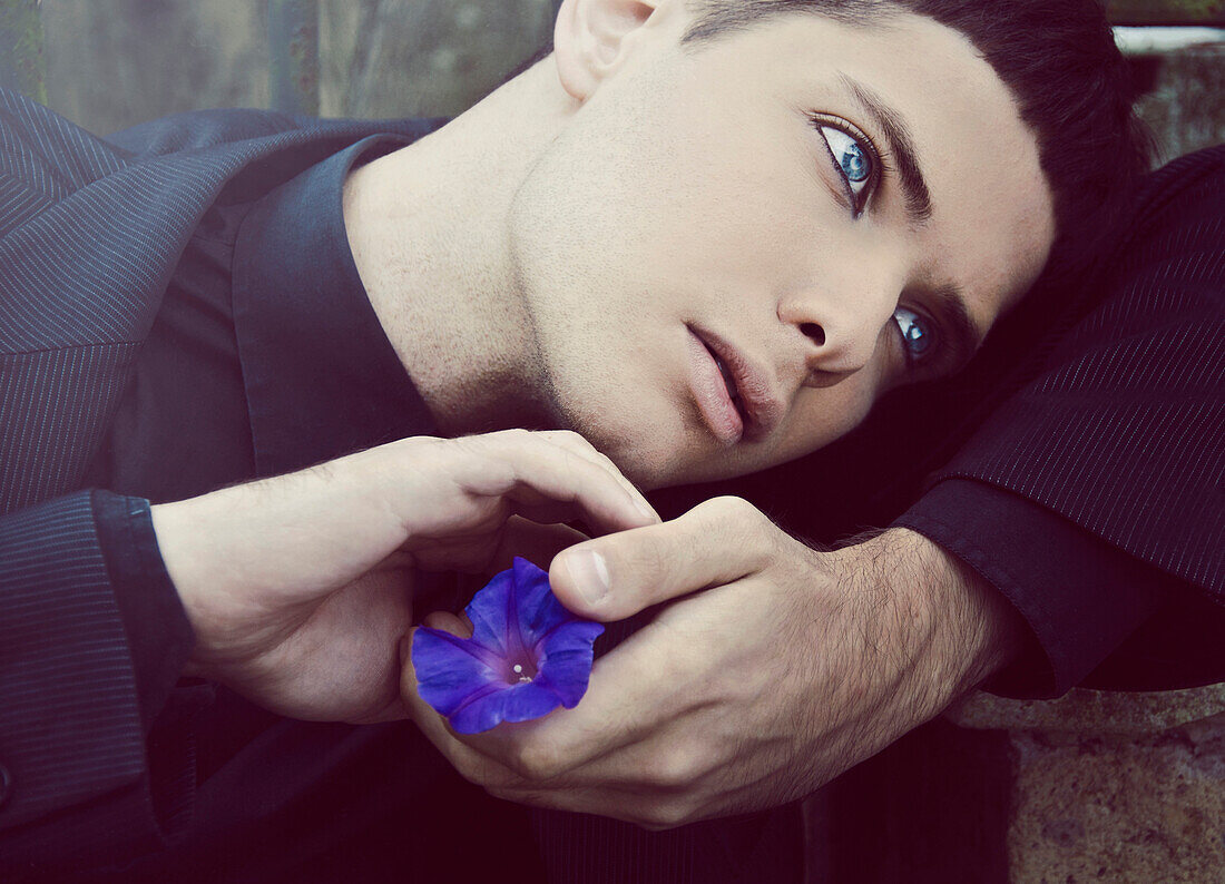 Young Man Holding Blue Flower, Portrait