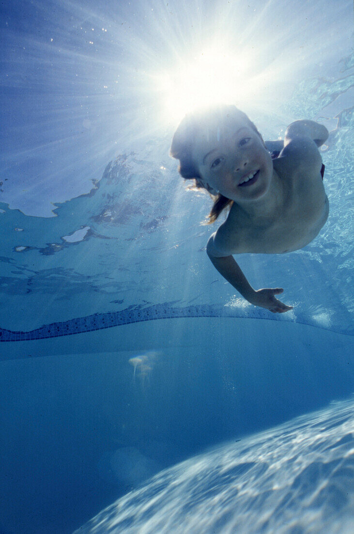 Boy Swimming Underwater, Backlit