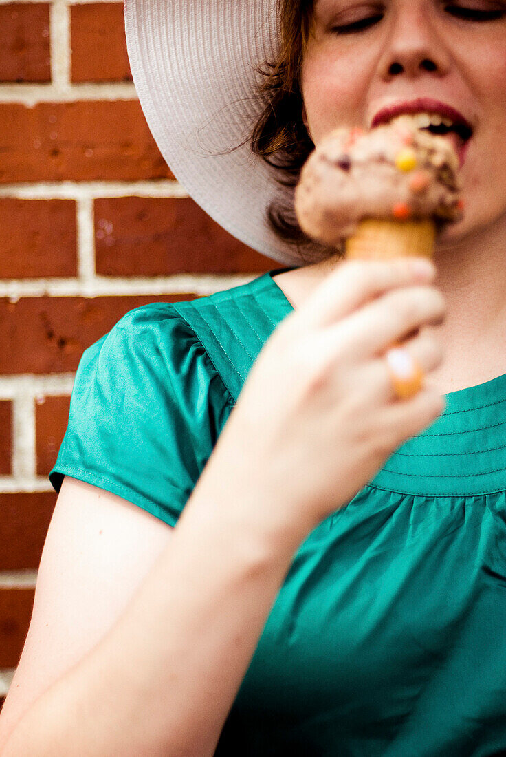 Junge Frau isst Eiscreme-Tüte