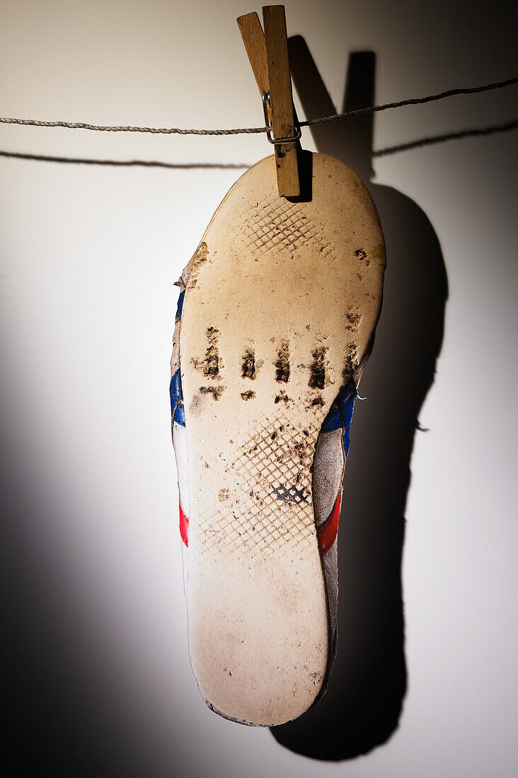Old Sneaker Clothespinned to Line, Rubber Sole Exposed