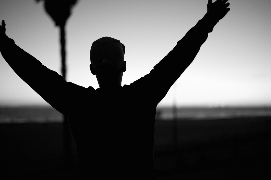 Man Holding Arms Up at Beach, Close-Up, Silhouette, Rear View