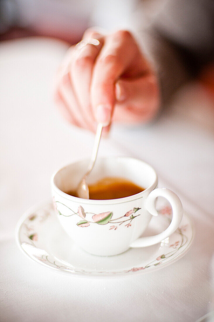 Woman Stirring Cup of Coffee