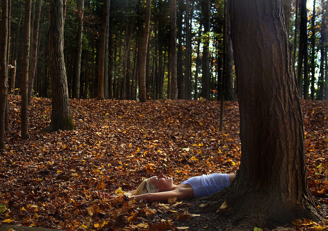 Woman Laying on Ground at Base of Tree