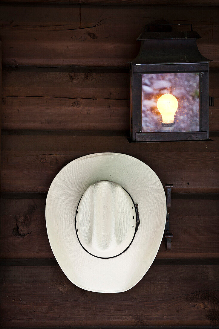 Cowboy Hat Hanging on Cabin Wall Next to Light Fixture